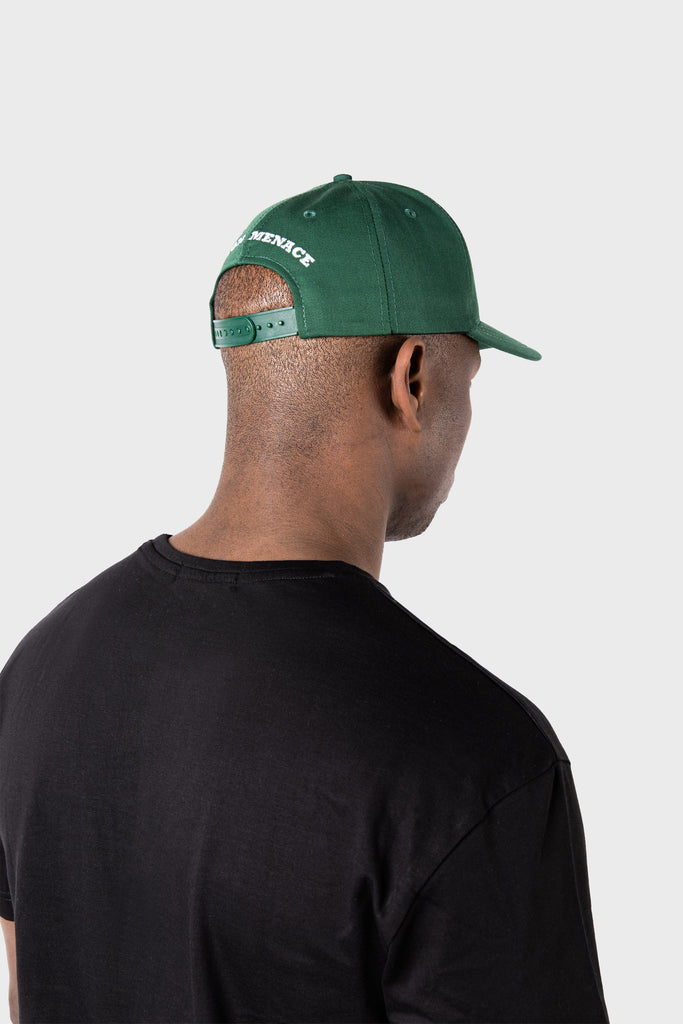 Viewed from behind against a plain light gray background, a person is wearing the MAISON MENACE Signature Hat in Cactus with white embroidery and a black t-shirt, highlighting the hats intricate details.