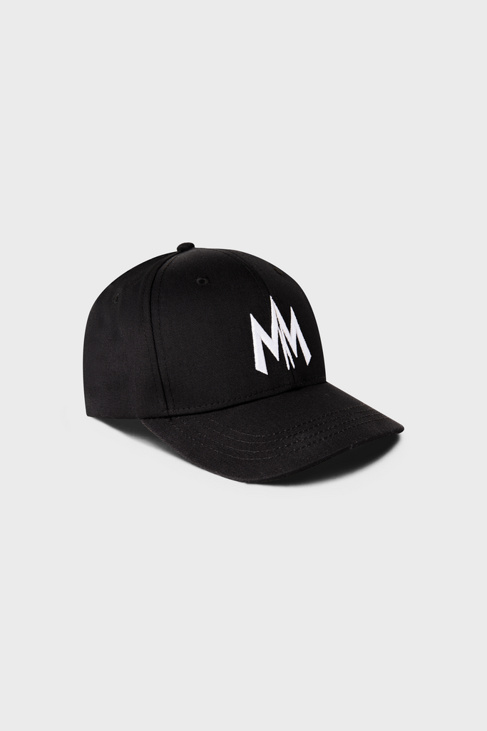 The Maison Menace Signature Hat by MAISON MENACE is a black cotton twill cap with white MM embroidery on the front and a classic curved brim, set against a plain gray background.