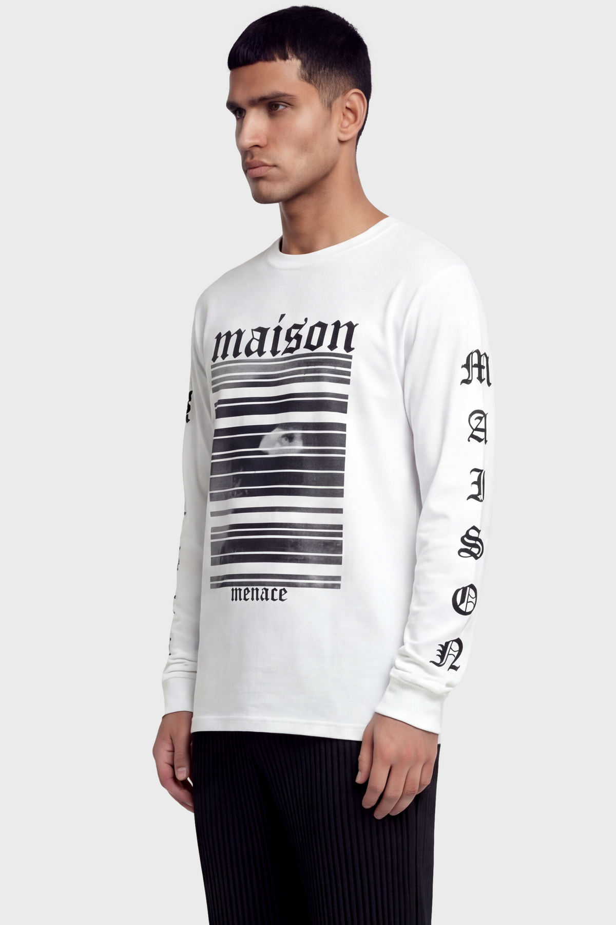 Man wearing a white long-sleeve t-shirt with black text and graphics on front and sleeves against white background