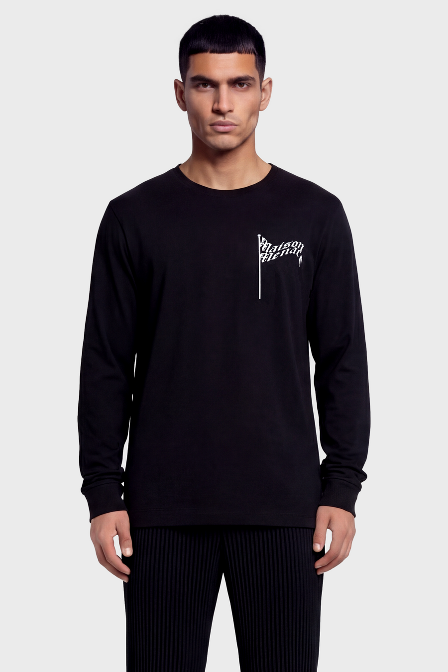 Man wearing a black long-sleeve t-shirt with a flag logo on a white background