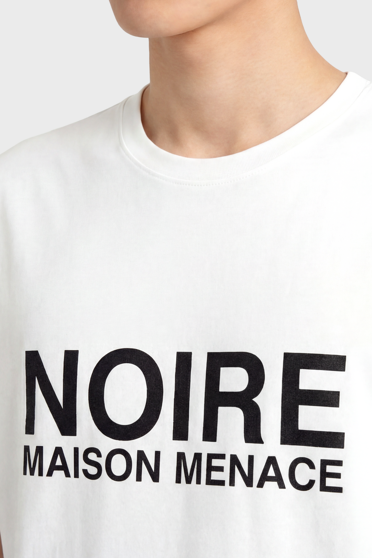 White t-shirt with 'NOIRE MAISON MENACE' text on a plain background