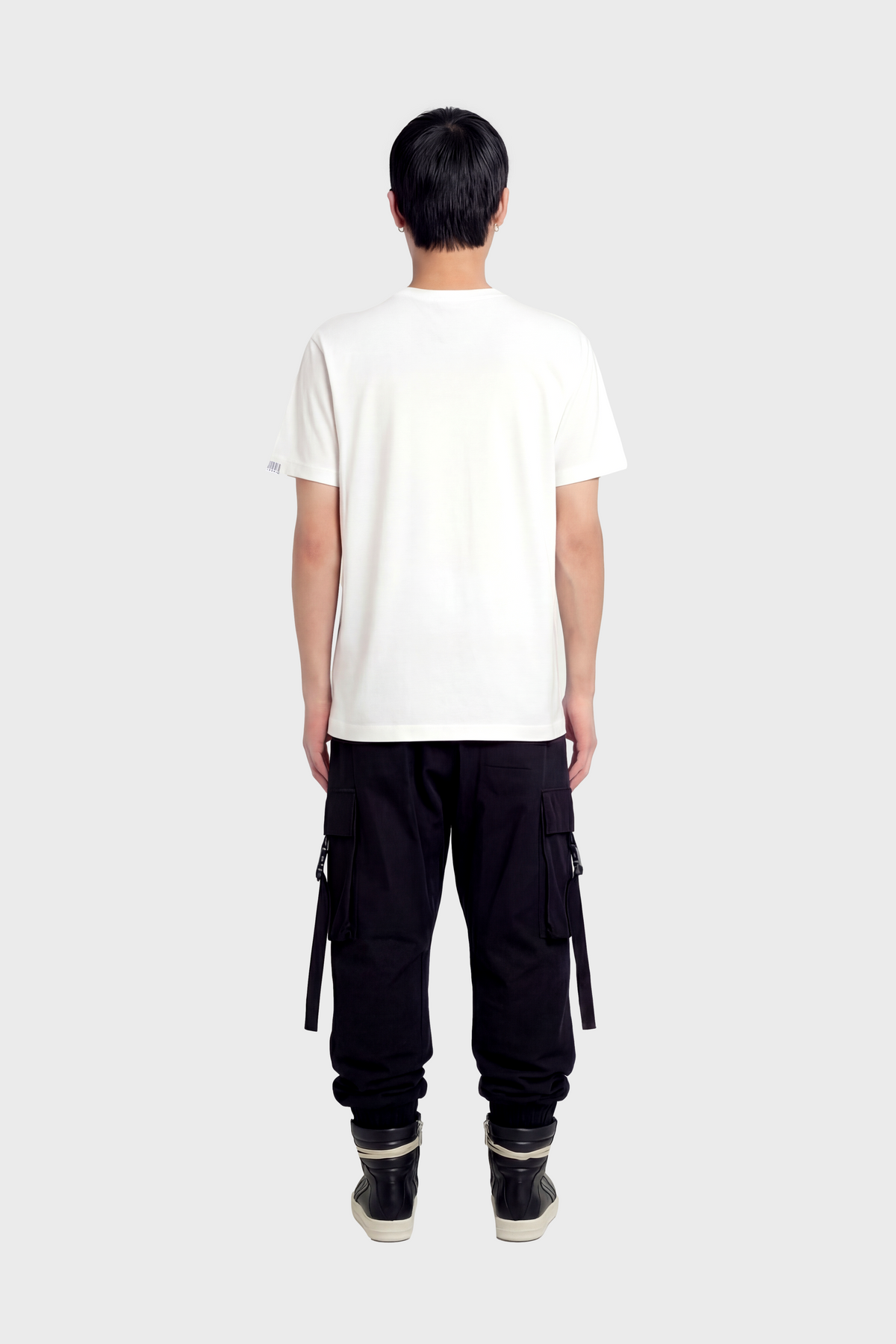 Person wearing a white t-shirt and black cargo pants on a white background