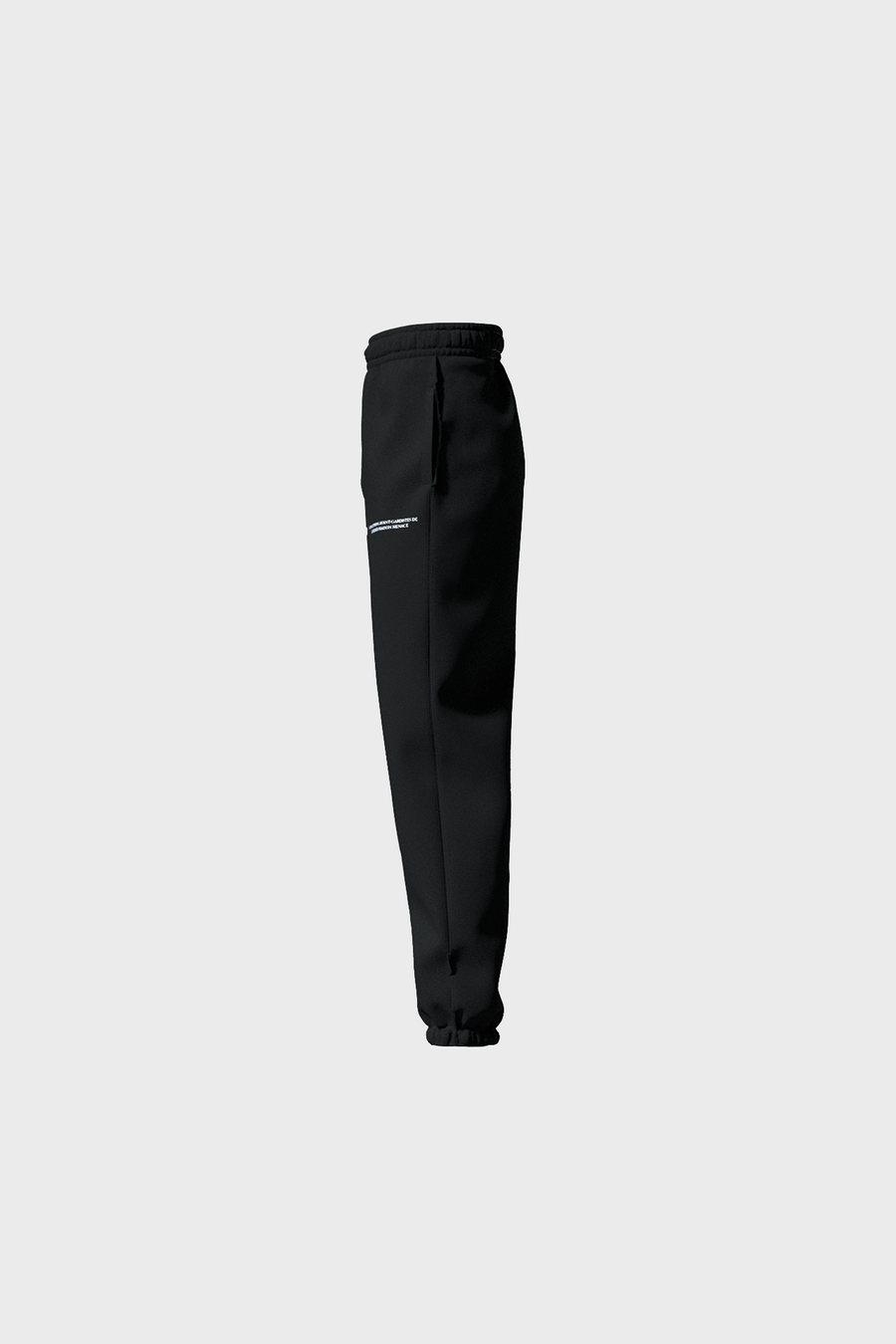 Side view of MAISON MENACEs Gothique Sweatpants in jet black soft cotton, featuring a small logo on the left thigh. Made in Portugal, these sweatpants have an elastic waistband and cuffs against a plain gray background.