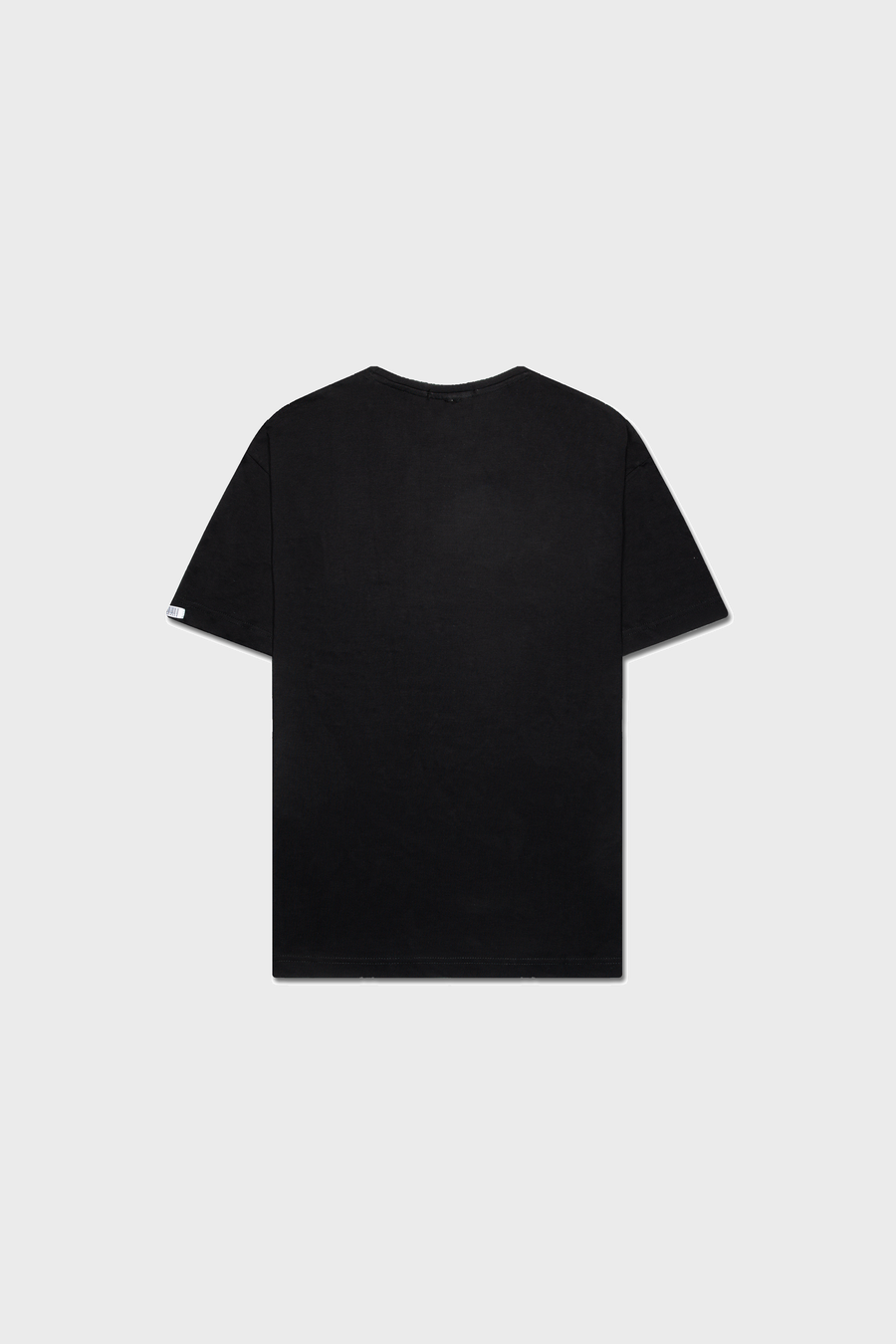 The Noire Classic T-Shirt by MAISON MENACE is shown from the back on a gray background, highlighting its short sleeves and straightforward design, crafted in plain black organic cotton.