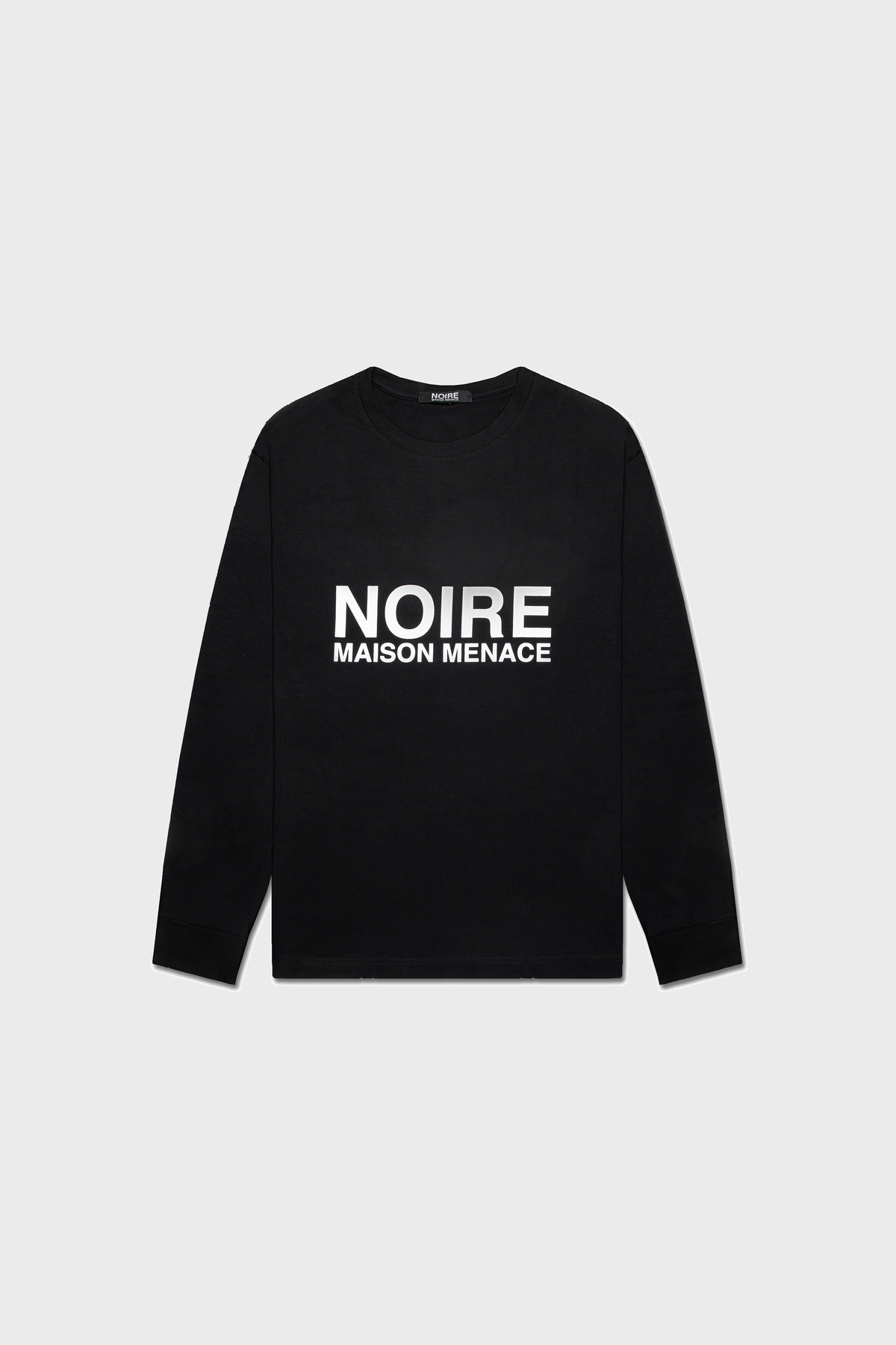 The Noire Classic Long Sleeve Shirt by MAISON MENACE is crafted from organic American Grown SUPIMA® cotton, featuring the bold NOIRE MAISON MENACE print in white capital letters on a neutral gray background.